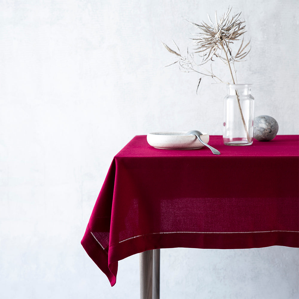 Mørkerød dug med broderet hulsøm