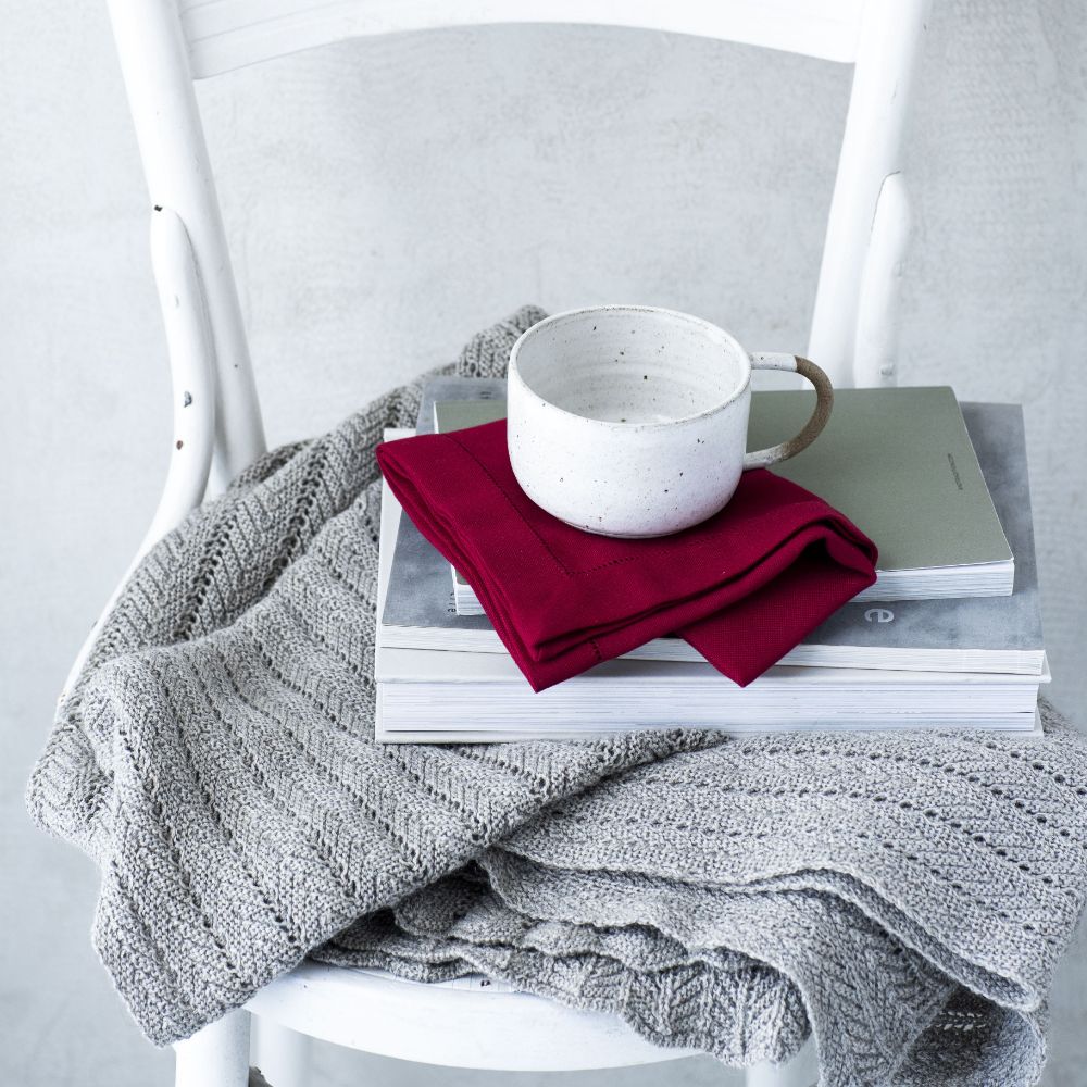 Mørkerød stofserviet med broderet hulsøm